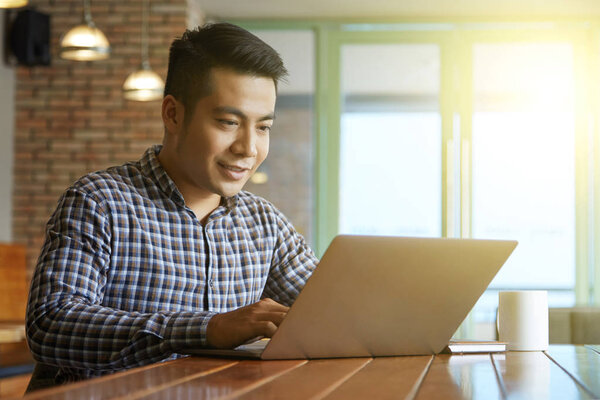 Businessman working at coffee shop at table