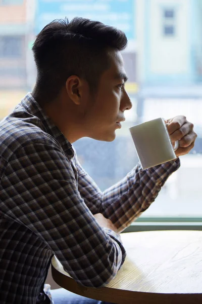 ハンサムな男のテーブルに座って カフェで大きなカップからコーヒーを飲む — ストック写真