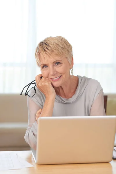 Experienced smiling business lady at laptop