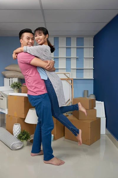 アジアの男妻を抱きしめるとボックスを移動すると新しいアパートに立ちながら幸せそうに笑って — ストック写真