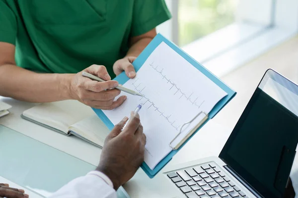 Médicos Sentados Mesa Discutiendo Cardiograma Juntos —  Fotos de Stock