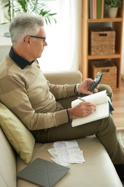 Komuta sizde giderleri hesaplama ve Not defteri ve evde oturma odasında kanepede oturan rakamları yazma 