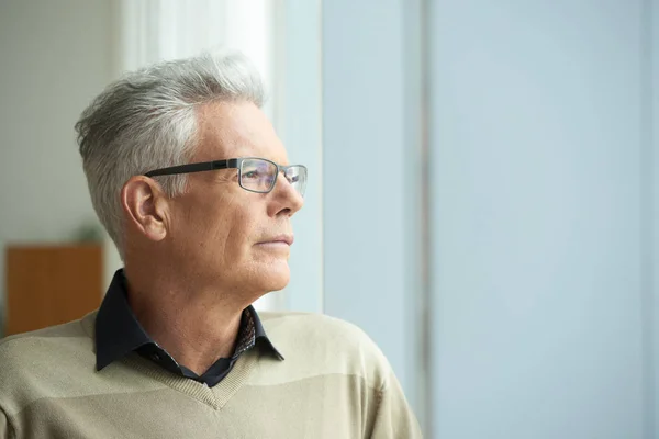 Porträtt Fundersam Senior Man Tittar Genom Fönstret — Stockfoto