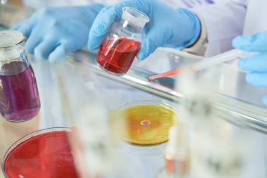 Lastik eldiven ve aşı ile çalışan beyaz ceket giyiyor bilim adamları