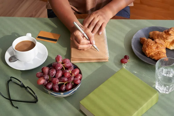 妇女在吃早餐时写想法 — 图库照片