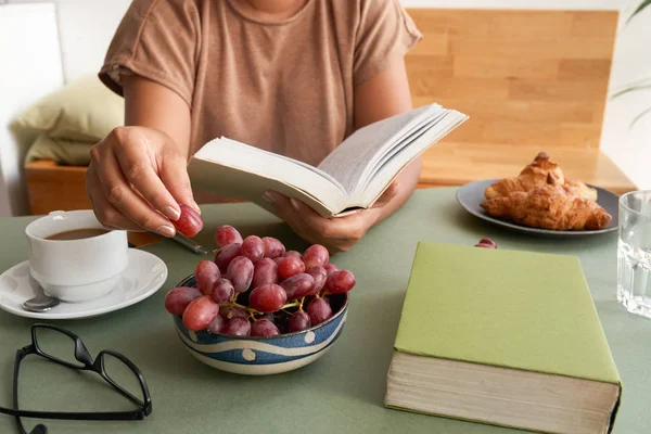 Imagen Recortada Mujer Leyendo Libro Mientras Sienta Mesa Cocina Comer — Foto de Stock