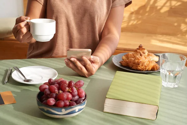 Oigenkännlig Kvinna Njuter Väldoftande Kaffe Och Surfa Mobiltelefon Vid Bord — Stockfoto