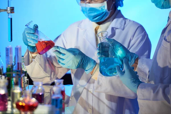 Группа Химиков Защитных Очках Белых Халатах Изучает Содержание Фляжек Лаборатории — стоковое фото