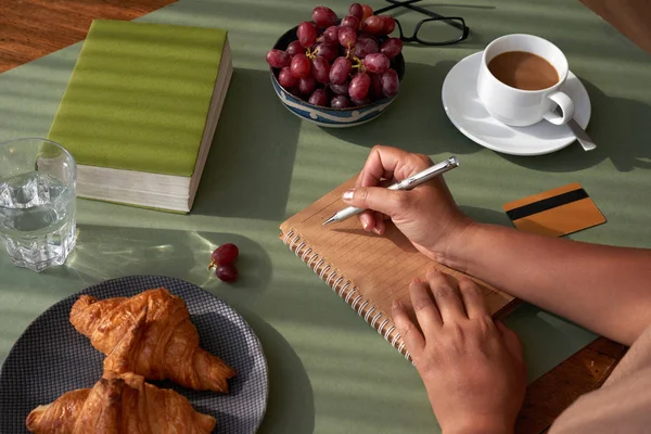 Unrecognizable Woman Sitting Kitchen Table Taking Necessary Notes Appetizing Croissants Royalty Free Stock Images