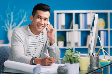 Neşeli genç mimar telefonla arıyor ve not alma