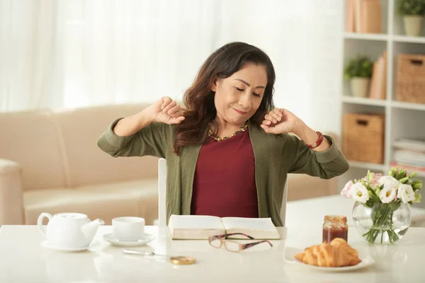 Asiatico Donna Matura Stretching Tavolo Durante Prima Colazione — Foto Stock