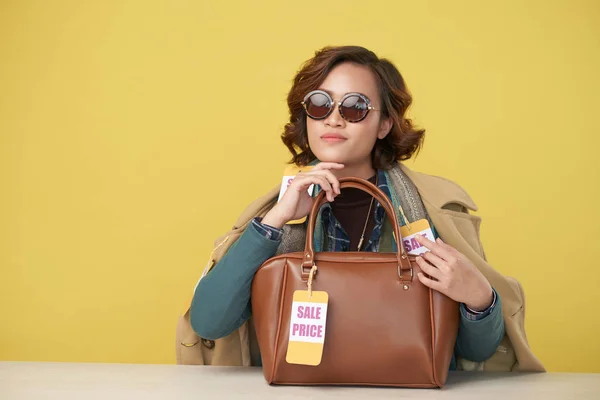 販売価格タグ付きハンドバッグを押し服の層を身に着けている魅力的な女性のポートレート — ストック写真