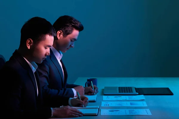 Business People Analyzing Financial Charts Writing Conclusions — Stock Photo, Image