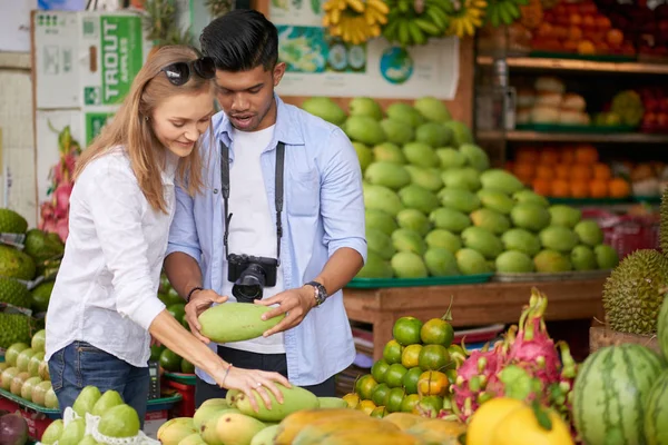 年轻的夫妇在街头市场选择有机水果的游客 — 图库照片