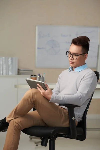 Joven Empresario Confiado Sentado Sillón Lectura Datos Pantalla Tableta — Foto de Stock