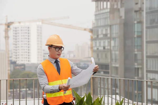 Junger Bauingenieur Begutachtet Bauplan Seinen Händen — Stockfoto
