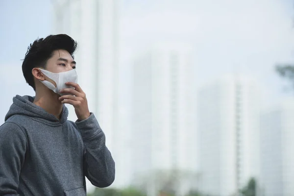Vietnamese young man in polluted city covered with heavy smog