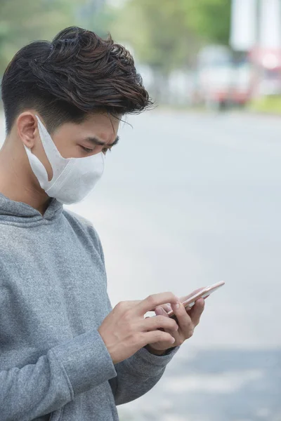 亚洲男子使用手机和戴口罩的面孔 城市空气污染 — 图库照片