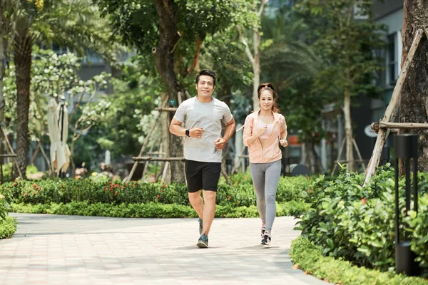 陽気な若いベトナム人カップル公園で実行しています — ストック写真