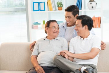 Büyükbaba, baba ve oğul evde kanepe 