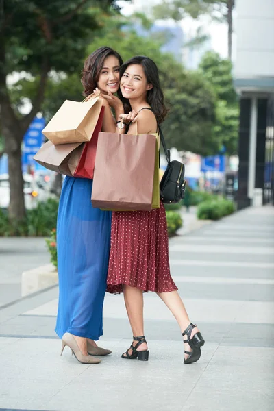 快乐的年轻妇女与购物袋站在户外 — 图库照片