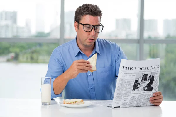 Чоловік Читає Шокуючі Місцеві Новини Коли Сніданок — стокове фото