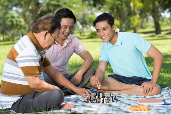 越南青少年在当地公园与他的父亲和祖父下棋 — 图库照片