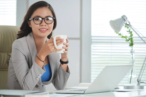 ノート パソコンとテーブルに座ってコーヒーの大きなマグカップでかなりアジア ビジネスの女性の肖像画 — ストック写真