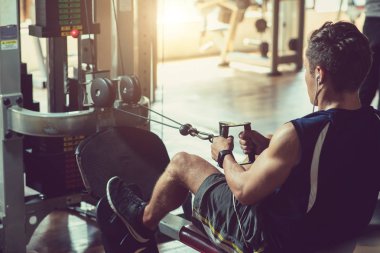 Genç adam simülatör spor salonunda egzersiz yerleştirmek