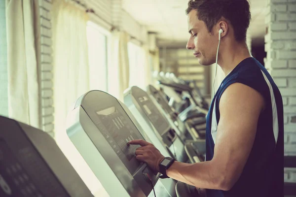 Sportlicher Junger Mann Wählt Programm Auf Laufband Fitnessstudio — Stockfoto