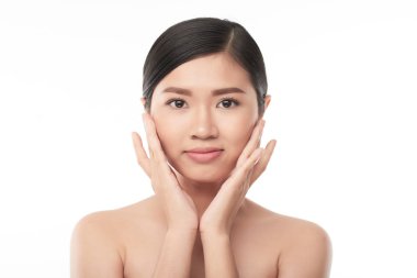 Yüzünde nemlendirici uygulayarak genç Vietnamlı kadın portresi