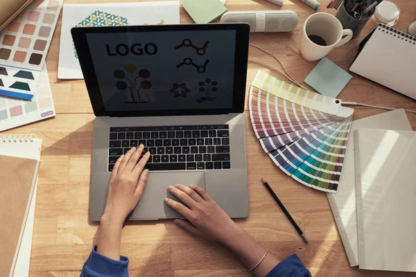 woman using laptop at table, logo and colors