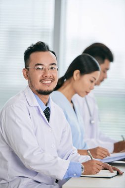 Mutlu Asya doktorlar, masada çalışan insanlar için konferansa pratisyen 
