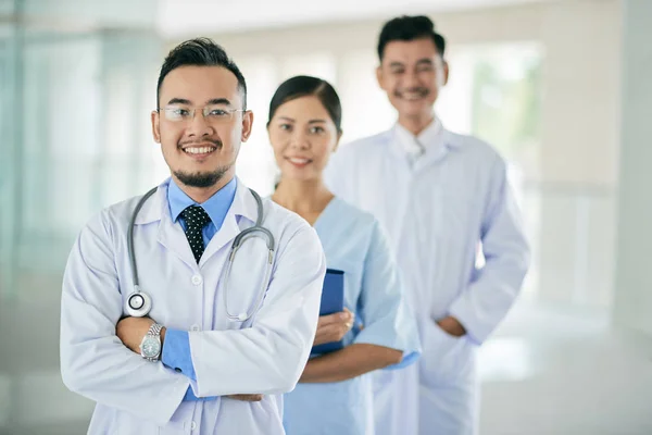 Веселий Азіатський Лікар Його Колеги Стоять Позаду — стокове фото