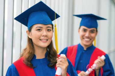Çok gülümseyen kız öğrencilerin mezuniyet şapka portresi