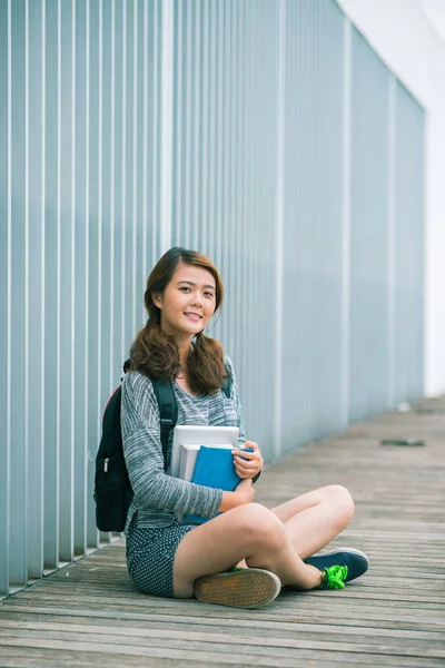 Fröhliche Vietnamesische Schülerin Mit Schulbüchern Auf Dem Boden Sitzend — Stockfoto