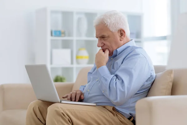 Pensivo Homem Sênior Sentado Sofá Trabalhando Laptop — Fotografia de Stock