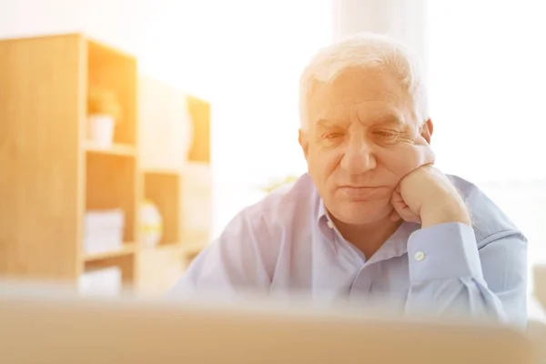 Nachdenklicher Älterer Mann Arbeitet Sonnigem Raum Computer — Stockfoto