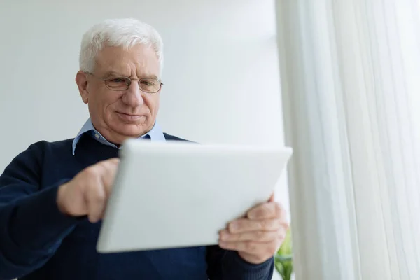戴眼镜的资深男士学习如何使用平板电脑 — 图库照片