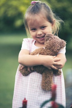 Küçük kız onu oyuncak ayı oyuncak sarılma gülümseyen 