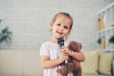 Mikrofon bir şarkı söylerken gülümseyen kız portresi