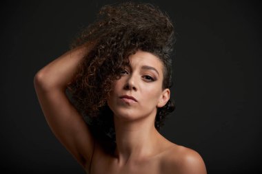 Kameraya bakarak kıvırcık saçlı güzel şehvetli genç kadın