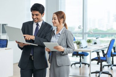 Dizüstü tutarak ve bir şey işkadını ofisinde için gösterilen işadamı