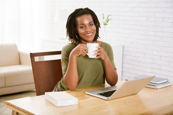 Gladlynt Kvinna Sitter Med Kopp Kaffe Vid Arbetsplatsen Bord Med — Stockfoto