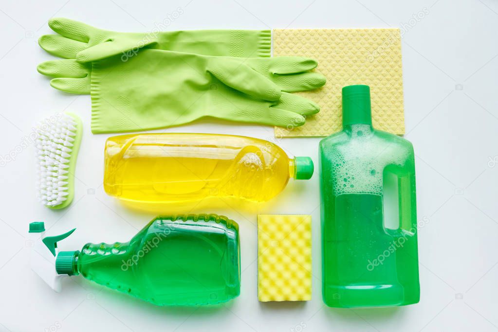 Cleaning products on white table, view from above