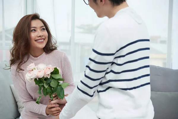 愉快的美丽的年轻妇女为她的男朋友接受花 — 图库照片