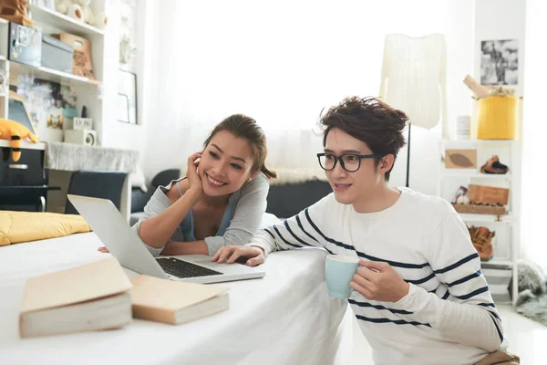 年轻的越南夫妇在家里看电影和微笑的笔记本电脑 — 图库照片