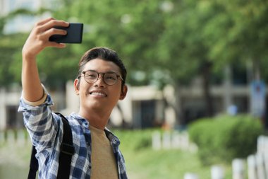 Genç Asyalı adam selfie açık alarak gözlük gülümseyen mobile ile 