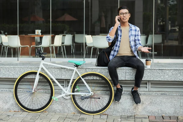 Junger Philippinischer Mann Sitzt Draußen Neben Seinem Fahrrad Und Telefoniert — Stockfoto