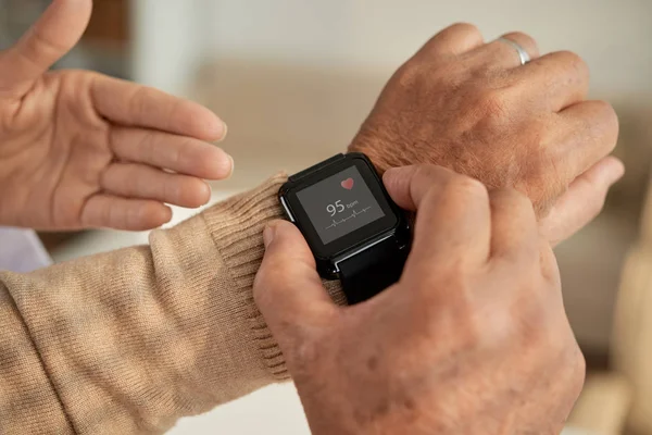 Senior man setting health application in his smart watch, cropped image